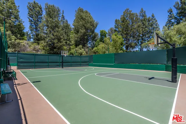 a view of a swimming pool with a yard and large trees