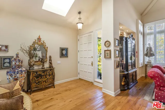 a view of a hallway with wooden floor and windows