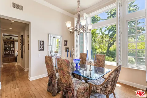 a dining room with furniture a chandelier and wooden floor