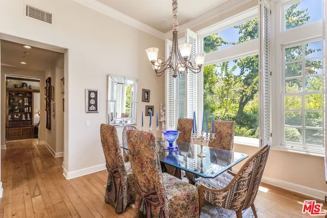 a dining room with furniture a chandelier and wooden floor