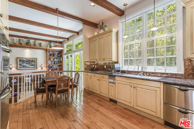 a kitchen with stainless steel appliances granite countertop a stove and cabinets next to a window