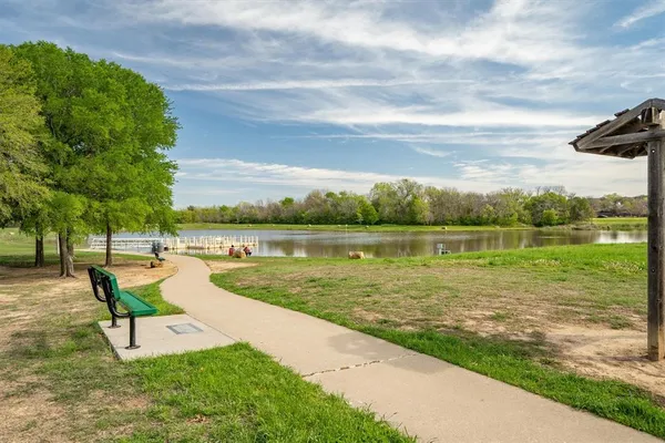 a view of a lake with couches and wooden fence