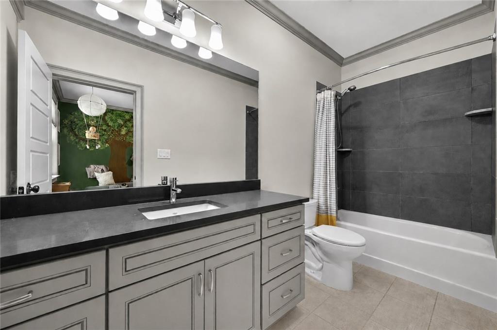 632 Geiger Road Jefferson, GA 30549 - Photo 38 of 55 a bathroom with a granite countertop sink a toilet a mirror and bathtub