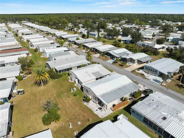 a view of a big house with a big yard and large trees