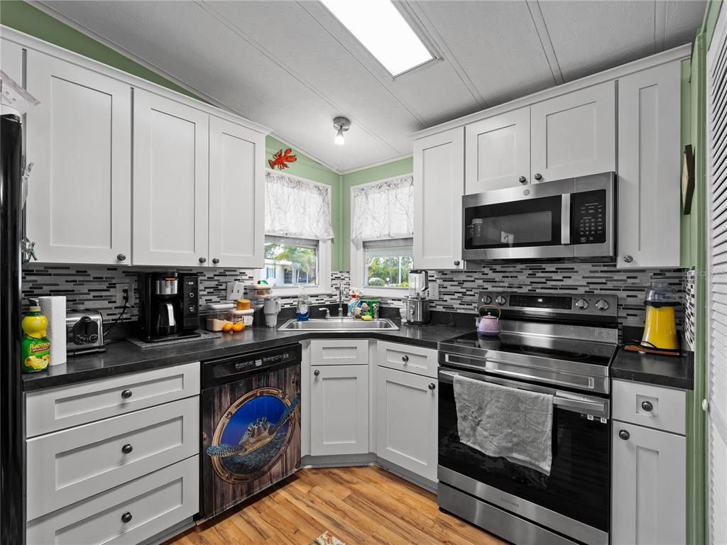 154 Rarotonga Road North Port, FL 34287 - Photo 7 of 47 a kitchen with stainless steel appliances granite countertop a stove a sink and a microwave