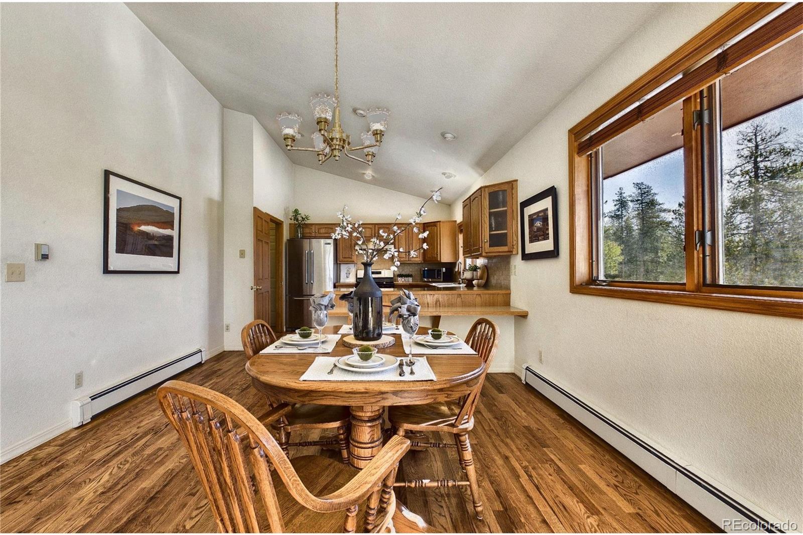 10798 Crystal Way Morrison, CO 80465 - Photo 12 of 36 a view of a dining room with furniture a chandelier and wooden floor