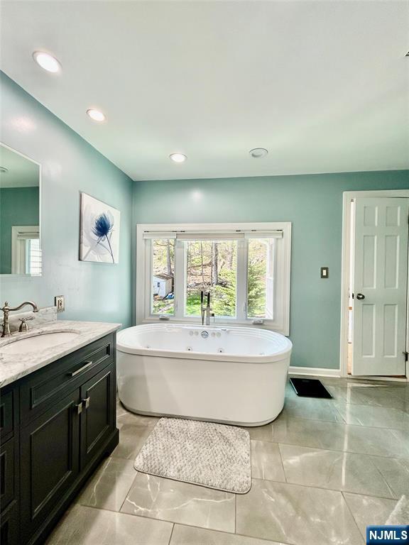 157 West Glen Road Denville, NJ 07834 - Photo 30 of 45 a spacious bathroom with a double vanity sink large mirror and a bathtub