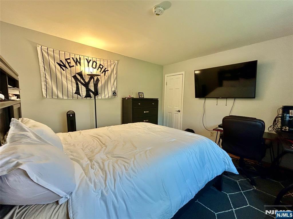 157 West Glen Road Denville, NJ 07834 - Photo 36 of 45 a bedroom with a bed and a flat screen tv