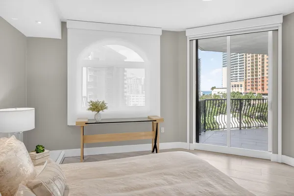a bedroom with a bed chandelier and a window