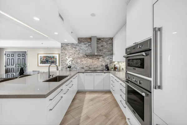 a kitchen with stainless steel appliances granite countertop a sink and stove top oven