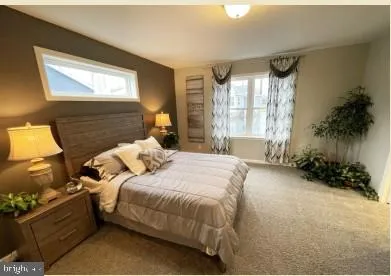 a bedroom with a bed and a potted plant