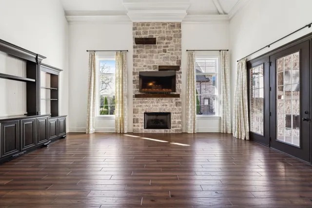 a kitchen with stainless steel appliances granite countertop wooden floors a stove and white cabinets