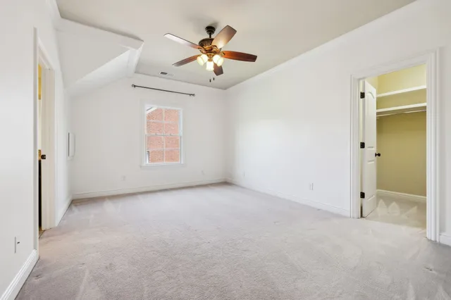 an empty room with a ceiling fan and a window