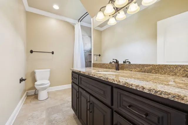 a bathroom with a granite countertop sink a toilet and a bathtub