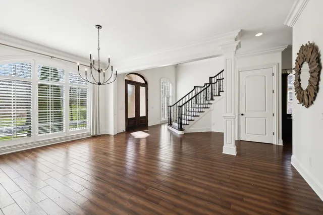 a view of a room with wooden floor windows and a chandelier