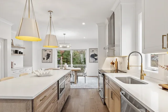 a kitchen with stainless steel appliances a sink a counter top space a large window and a sink