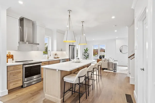 a kitchen with stainless steel appliances a table chairs sink and stove top oven