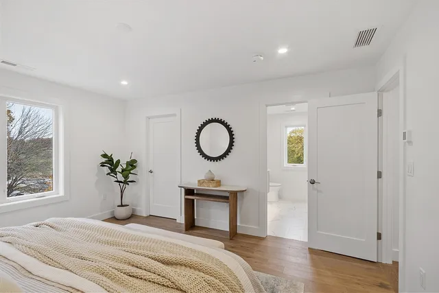 a spacious bedroom with a bed and a painting on the wall