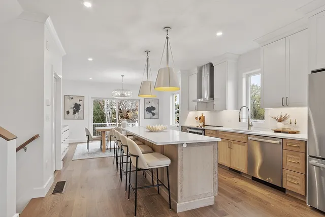 a kitchen with counter top space sink stove and wooden floor