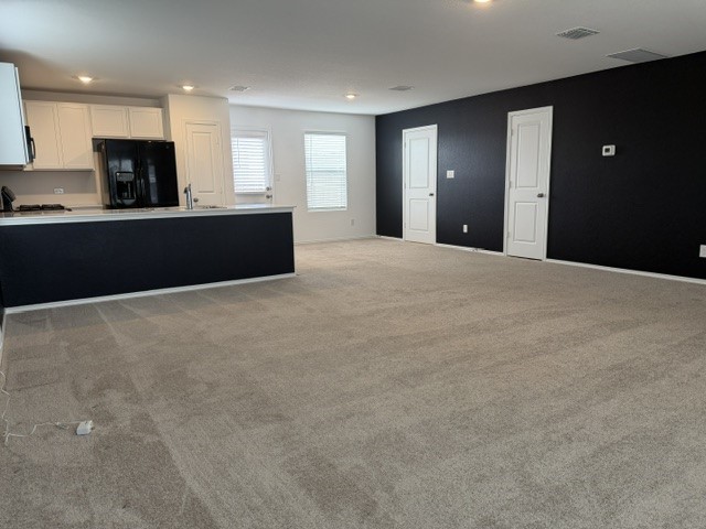 572 Avre Loop Kyle, TX 78640 - Photo 4 of 13 An open layout connects the carpeted living space directly to the functional kitchen area.