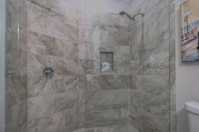 a bedroom with a bed a couch and a chandelier