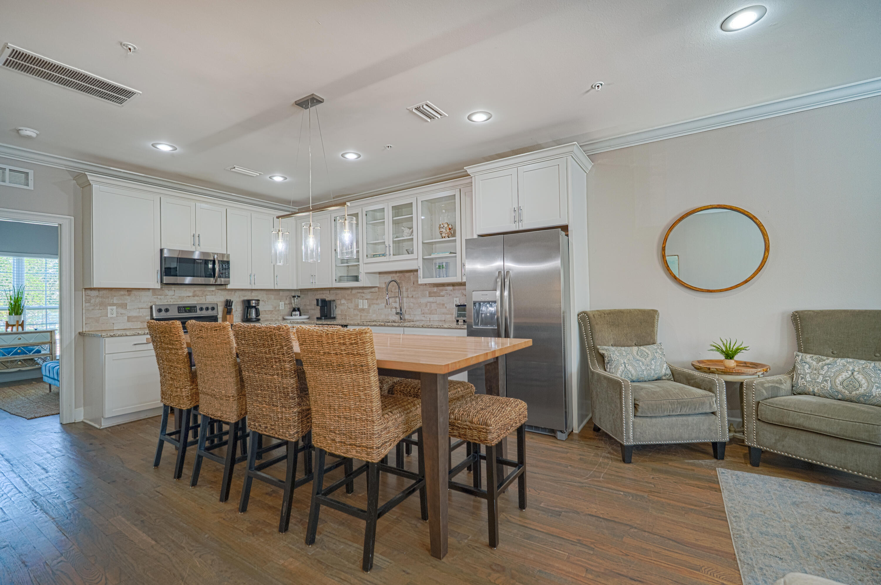 257 Driftwood Road, Unit 1 Miramar Beach, FL 32550 - Photo 9 of 36 a kitchen with stainless steel appliances granite countertop a dining table chairs refrigerator sink and cabinets
