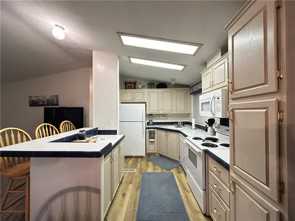 a kitchen with stainless steel appliances kitchen island granite countertop a refrigerator a stove a sink and dishwasher