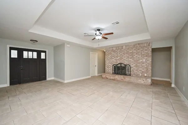wooden floor fireplace and windows in an empty room