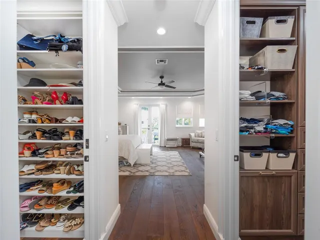 a view of walk in closet with clothes and shoes