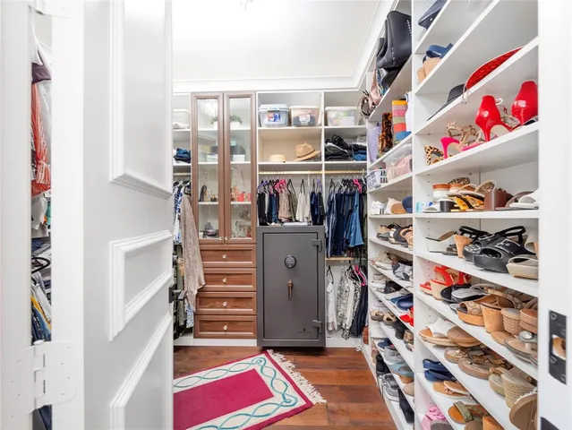 a view of walk in closet with clothes and shoes