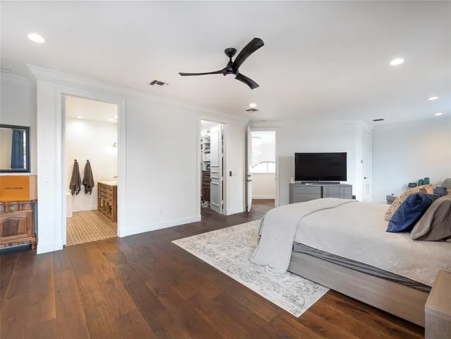 a spacious bedroom with a bed and a flat screen television