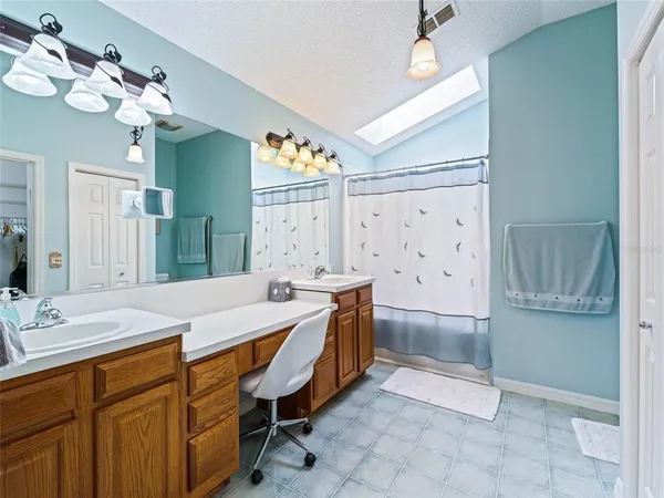 a spacious bathroom with a granite countertop sink a toilet and mirror