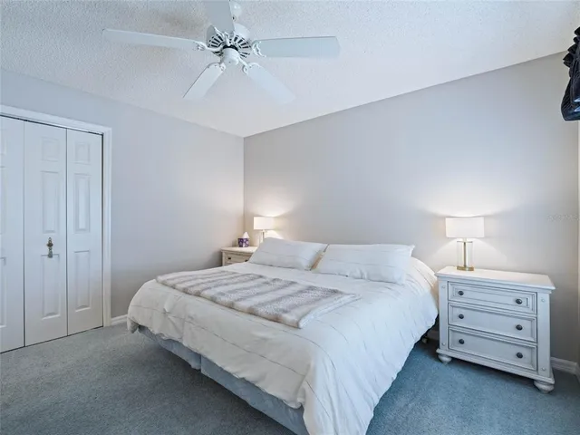a bedroom with a bed and a ceiling fan