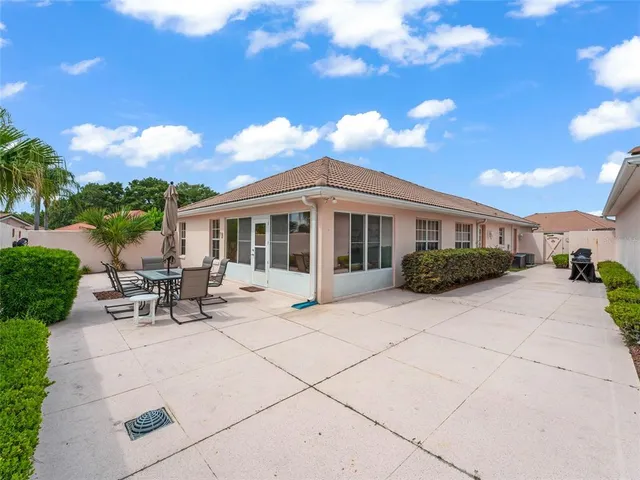a view of a patio with table and chairs and floor to ceiling window