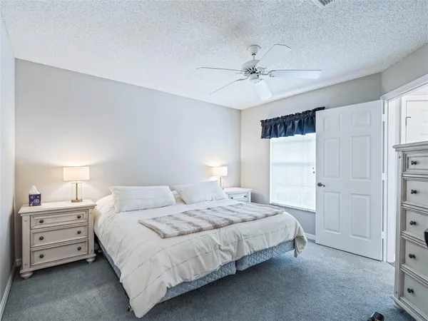 a bedroom with a bed and a ceiling fan