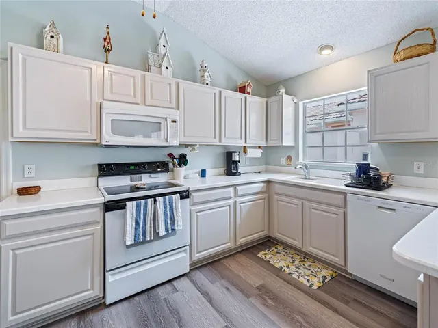 a kitchen with cabinets appliances a sink and a counter space