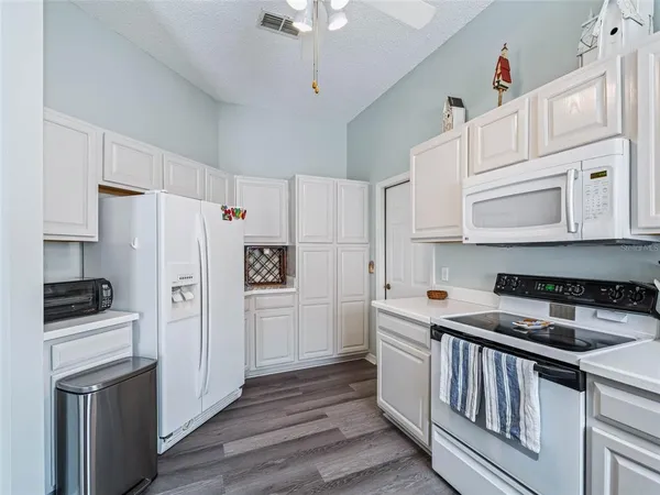 a kitchen with stainless steel appliances a refrigerator stove and white cabinets