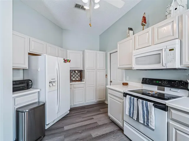a kitchen with stainless steel appliances a refrigerator stove and white cabinets