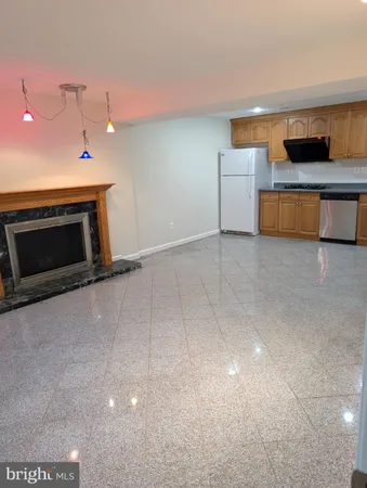 a view of a kitchen with kitchen island a sink wooden floor and a refrigerator
