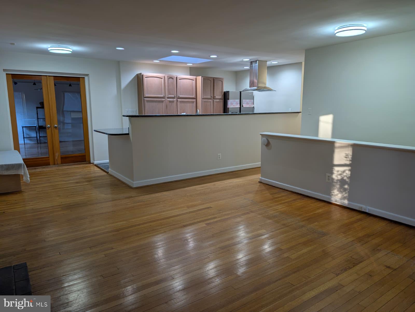 6705 Goldsboro Road Bethesda, MD 20817 - Photo 21 of 60 a view of a kitchen with kitchen island a sink wooden floor and a refrigerator