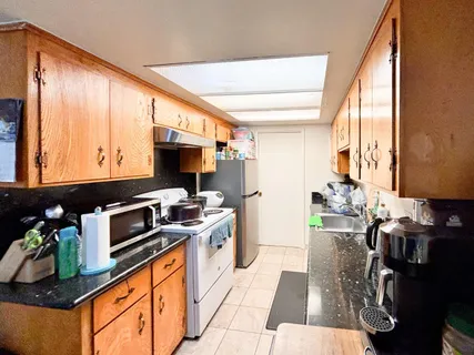 a kitchen with stainless steel appliances a stove top oven and a refrigerator