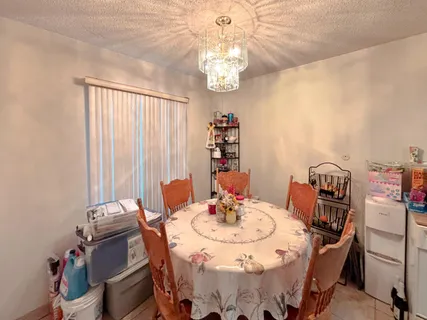 a view of a dining room with furniture and chandelier