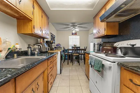 a kitchen with stainless steel appliances granite countertop a sink stove and cabinets