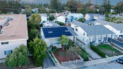 an aerial view of multiple houses with a yard
