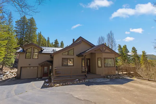 a view of a house with a patio and a yard