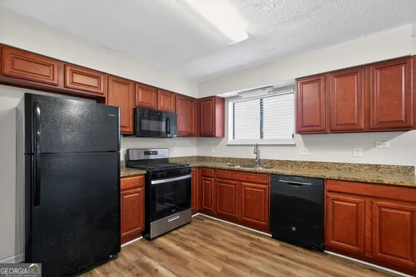 a kitchen with stainless steel appliances granite countertop a refrigerator and a sink