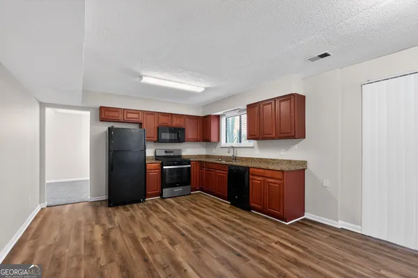 a kitchen with stainless steel appliances granite countertop a refrigerator stove and oven
