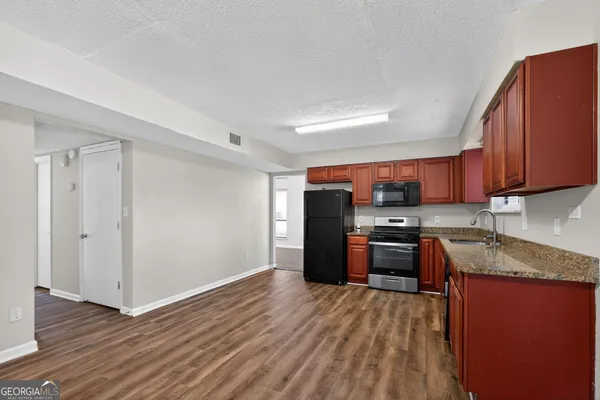 a kitchen with stainless steel appliances granite countertop a refrigerator stove and sink