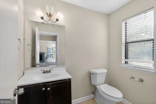 a bathroom with a toilet a sink and mirror