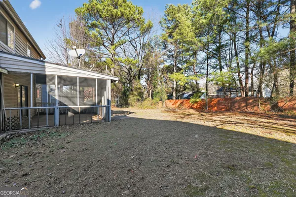 a view of a yard with wooden fence